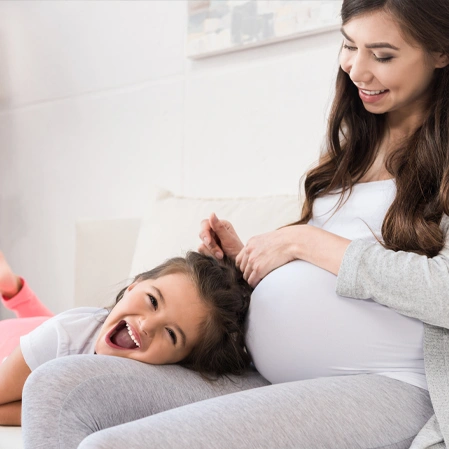 Person reclining on a couch with a visible pregnant belly